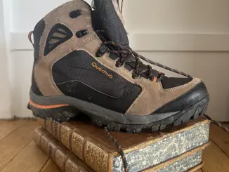 Une chaussure de randonnée posée sur un livre ancien relié
